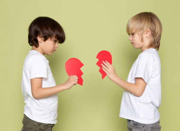 front-view-two-boys-white-t-shirts-holding-red-teared-heart-shape-stone-colored-space