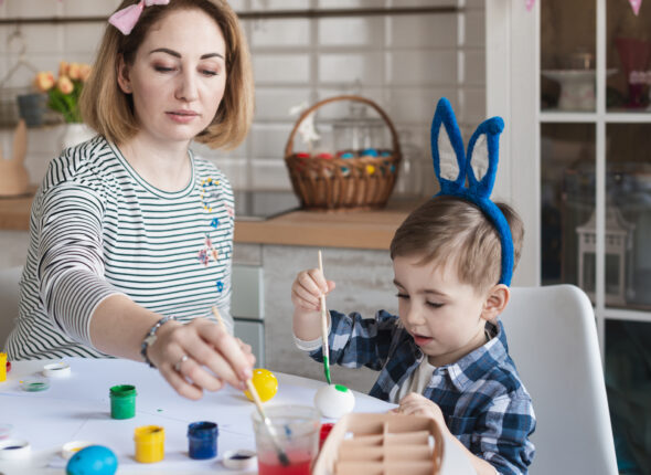 mother-teaching-little-boy-how-paint-eggs-easter